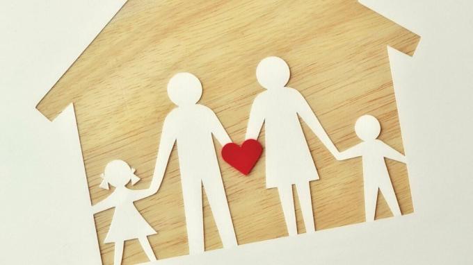 Popieriaus šeima ant medinio namo, turinti širdį reprezentuoti meilę, palaikymą ir ADHD pagalbą